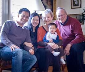 Member couple at home hosting an international couple and their baby.