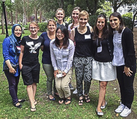 Group of nine smiling female internationals at a social event in the park.