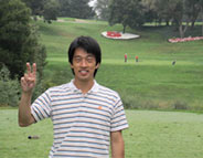 Male international, on a golf course, making the peace sign with two fingers.