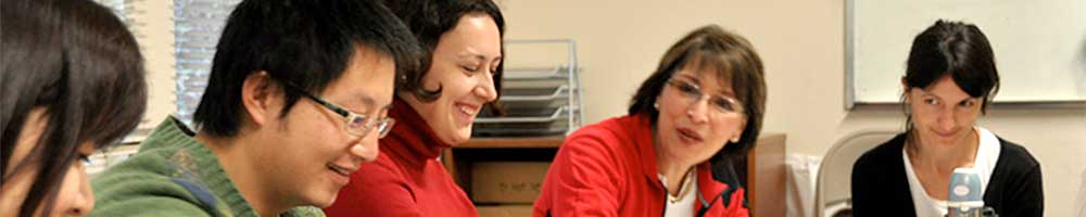 Happy volunteer instructor and internationals in English class.