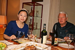 Smiling female international enjoying dinner at the home of her male Hospitality host (and his wife).